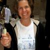 Jane Bolster, Grinnell Centennial Planning Team wearing a Centennial T-shirt her daughter designed and brandishing a cake knife. (Photo: Sally Kahan)